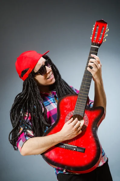 Grappige man die gitaar speelt in muzikaal concept — Stockfoto