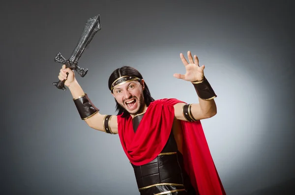 Romeinse krijger met zwaard tegen achtergrond — Stockfoto