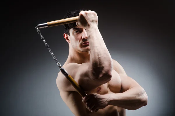 Musclé homme fort avec des nunchakus — Photo