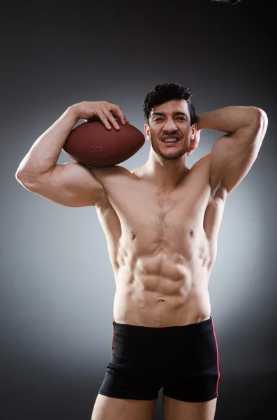 Homem musculoso com futebol americano — Fotografia de Stock