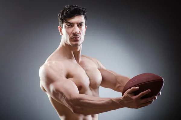 Homem musculoso com futebol americano — Fotografia de Stock