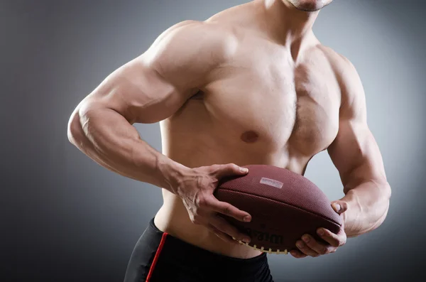 Homem musculoso com futebol americano — Fotografia de Stock