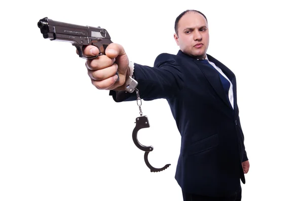 Homem com arma e algemas no branco — Fotografia de Stock