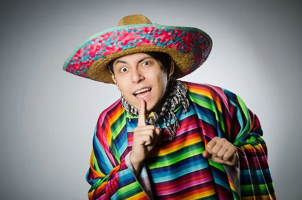 Hombre en poncho mexicano vívido contra gris — Foto de Stock