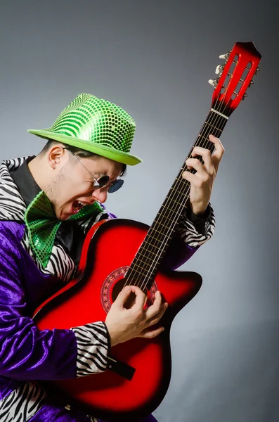 Смешной человек играет на гитаре в музыкальной концепции — стоковое фото