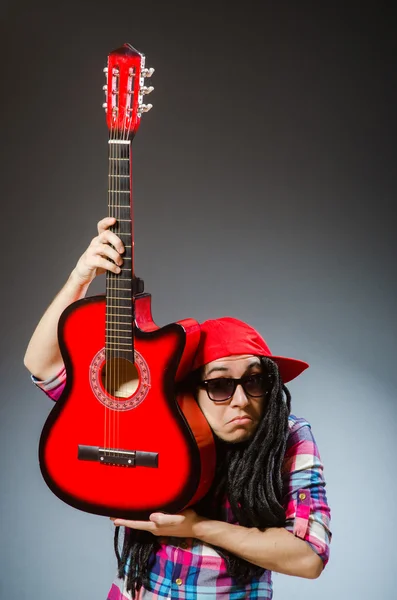 Grappige man die gitaar speelt in muzikaal concept — Stockfoto