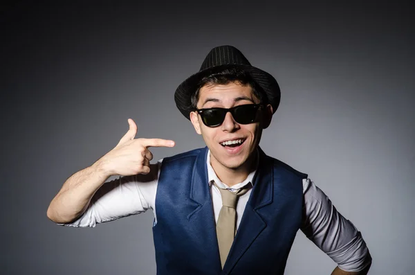 Hombre joven en chaleco azul y sombrero contra gris —  Fotos de Stock