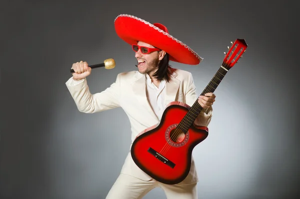 Divertido mexicano de traje sosteniendo la guitarra contra el gris — Foto de Stock