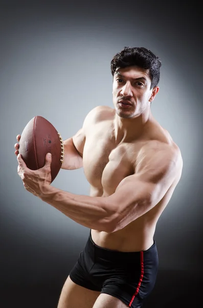 Homem musculoso com futebol americano — Fotografia de Stock