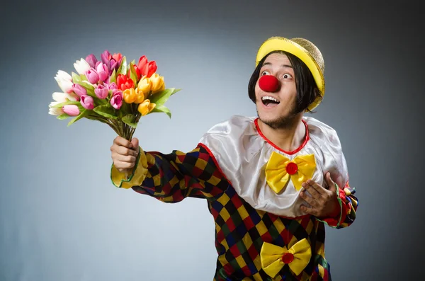 Clown avec des fleurs de tulipes dans un concept drôle — Photo