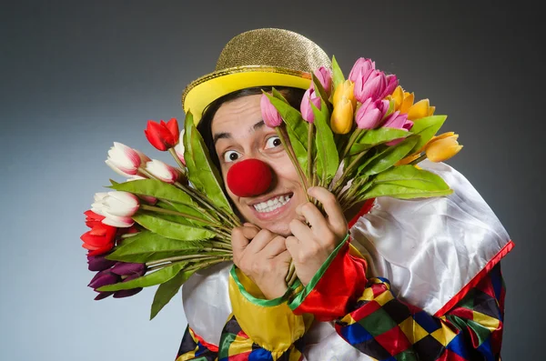 Clown avec des fleurs de tulipes dans un concept drôle — Photo