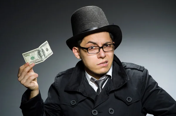 Young man in black coat holding money against gray — Stock Photo, Image