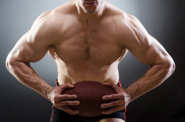 Muskulös man med amerikansk fotboll — Stockfoto