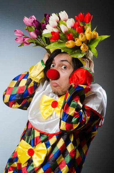 Clown avec des fleurs de tulipes dans un concept drôle — Photo