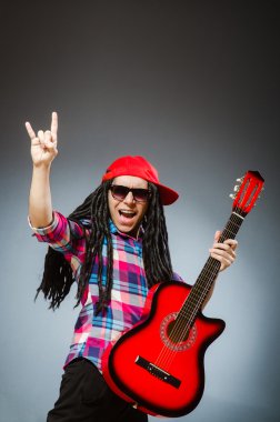 Müzik konseptinde gitar çalan komik bir adam.