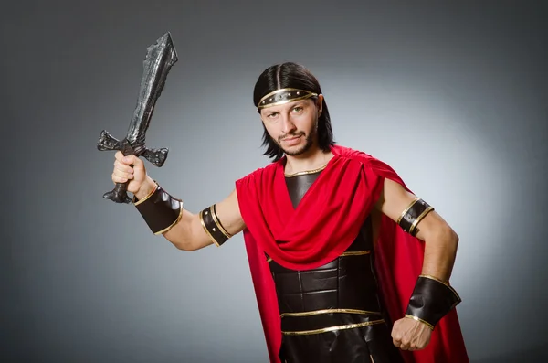 Římský bojovník s mečem proti šedé pozadí — Stock fotografie