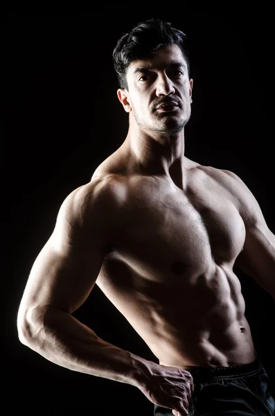 Homem muscular posando em estúdio escuro — Fotografia de Stock