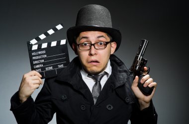 Genç adam silah ve gri karşı fıçı tahtası