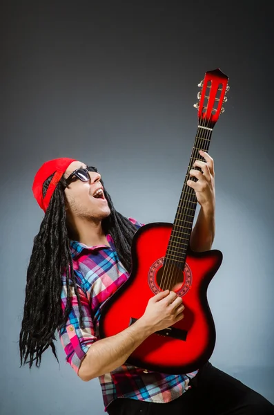 Homem engraçado tocando guitarra no conceito musical — Fotografia de Stock