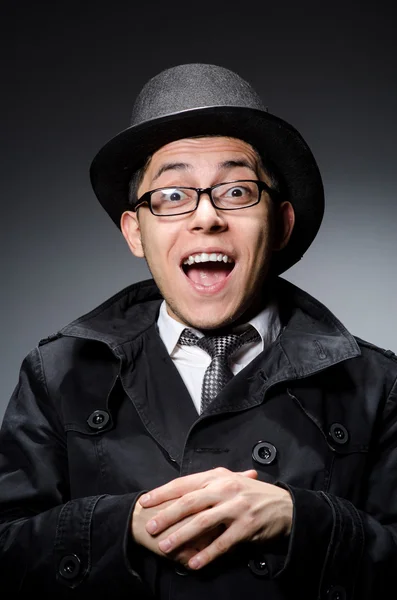 Joven con abrigo negro y sombrero contra gris —  Fotos de Stock