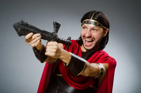 Римский воин с мечом на сером фоне — стоковое фото