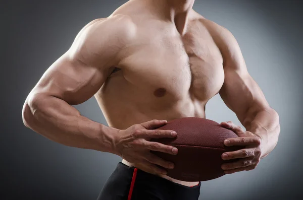 Uomo muscoloso con calcio americano — Foto Stock