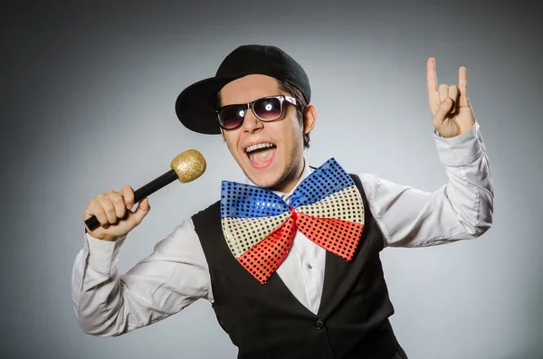 Zabawny człowiek z mikrofonem w koncepcji karaoke — Zdjęcie stockowe