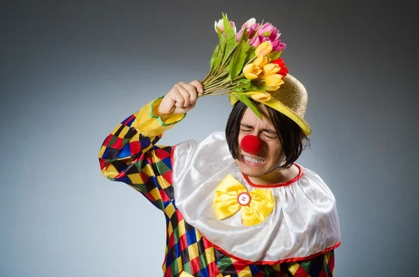 Clown avec des fleurs de tulipes dans un concept drôle — Photo