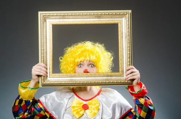 Клоун в смешной концепции на сером фоне — стоковое фото
