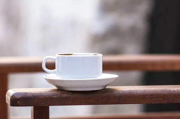 Tazza di caffè sul braccio della sedia — Foto Stock