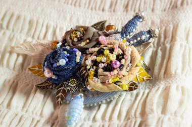 Nakışlı çiçekli tekstil broşu.