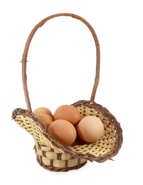 Пасхальні яйця в коричневому кошику на білому тлі — стокове фото