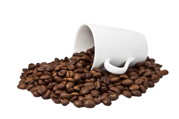 Grãos de café em uma xícara branca e disseminado sobre uma panela de café — Fotografia de Stock