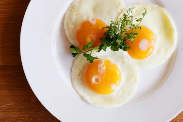 Three fried eggs with herbs — Free Stock Photo