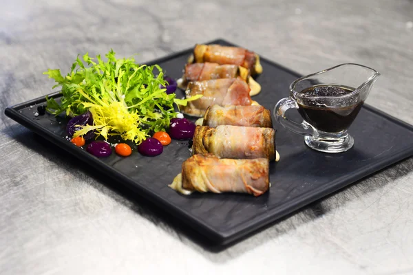 Bacon Roulé Avec Salade Verte Fraîche Sur Plaque Noire — Photo