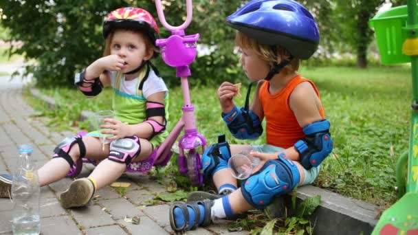 Crianças com scooters comer biscoitos — Vídeo de Stock