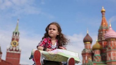 Kız oturur ve büyük Haritaya benziyor