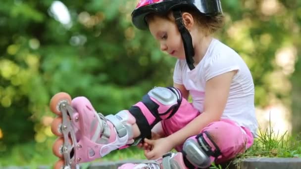 Meisje met rollen vastmaakt knie-pad — Stockvideo