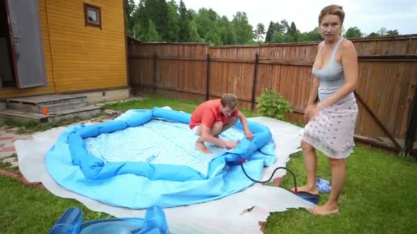 Mann und Frau pumpen Pool für Kinder — Stockvideo