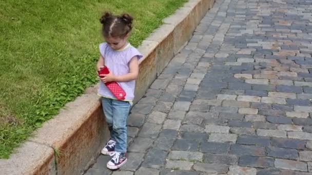 Дівчинка тримає смартфон — стокове відео