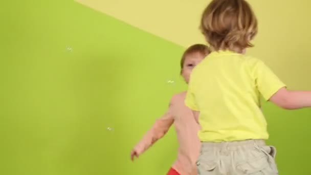 Маленька дівчинка і хлопчик стрибають — стокове відео