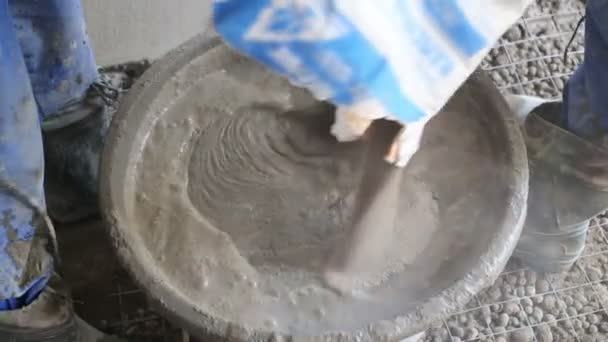 Arbeiter in Gummistiefeln bereiten Betonmörtel vor — Stockvideo