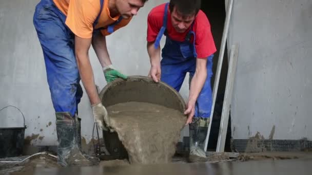 Dos trabajadores en botas de goma vierte cubo — Vídeos de Stock