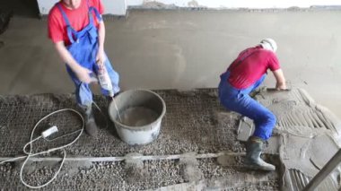 Worker preparing concrete grout for floor