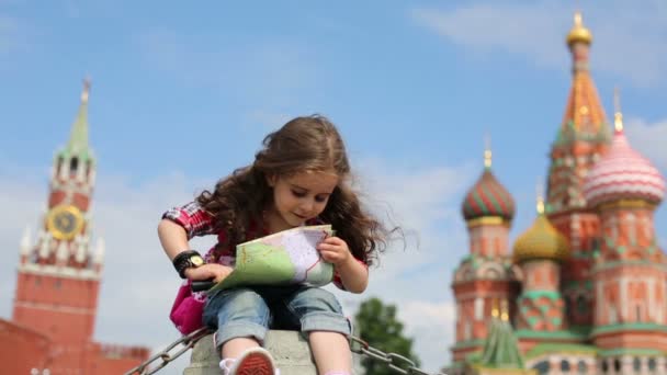 Dívka sedí s lupou a mapa — Stock video