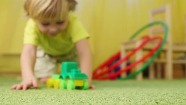 Pequeño niño juega con juguete — Vídeo de stock