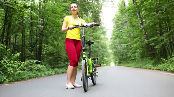 Женщина с велосипедом в парке — стоковое видео