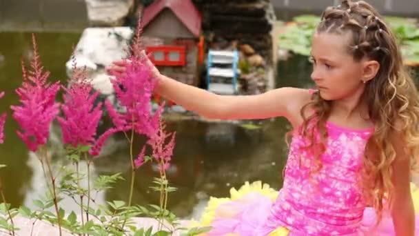 Küçük kız gölet yanında oturur — Stok video