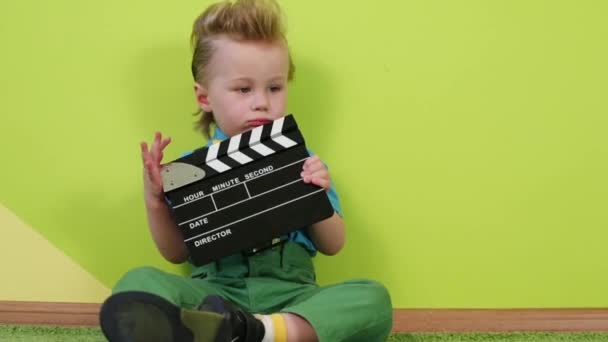 Niño pequeño con clapboard — Vídeo de stock