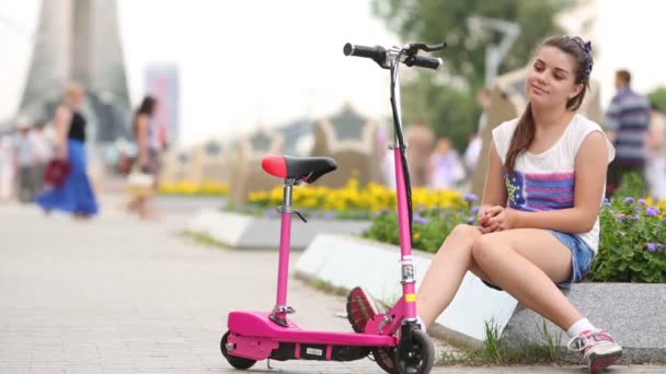Menina com scooter senta-se — Vídeo de Stock